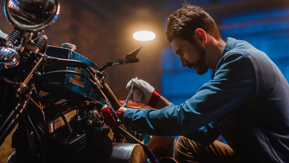 Young,Handsome,Mechanic,Is,Fixing,A,Custom,Bobber,Motorcycle.,Close