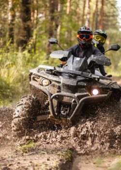 A,Quad,Moving,Trough,The,Mud,With,Two,Riders,On